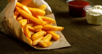 7 อาหารยอดแย่ ตัวการแก่เร็ว!! Fresh fried french fries with ketchup on wooden background